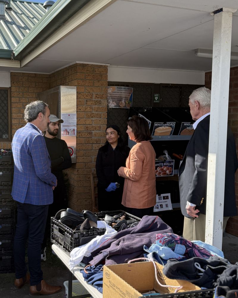 The Governor and Dr Walters speak with people outside a community house