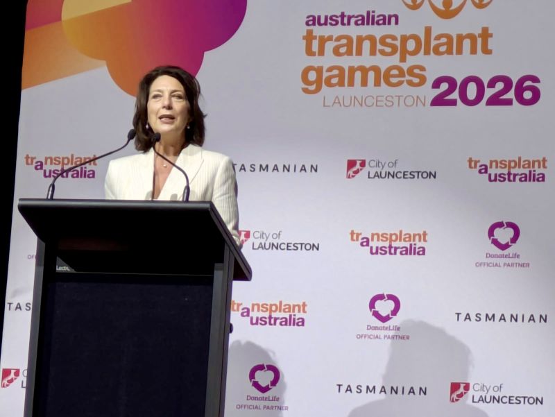 The Governor stands at a lectern on stage, with a sign behind her reading Australian Transplant Games