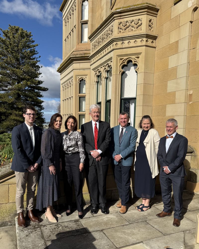 The Governor and Dr Walters stand outdoors with three men and two women, everyone is smiling