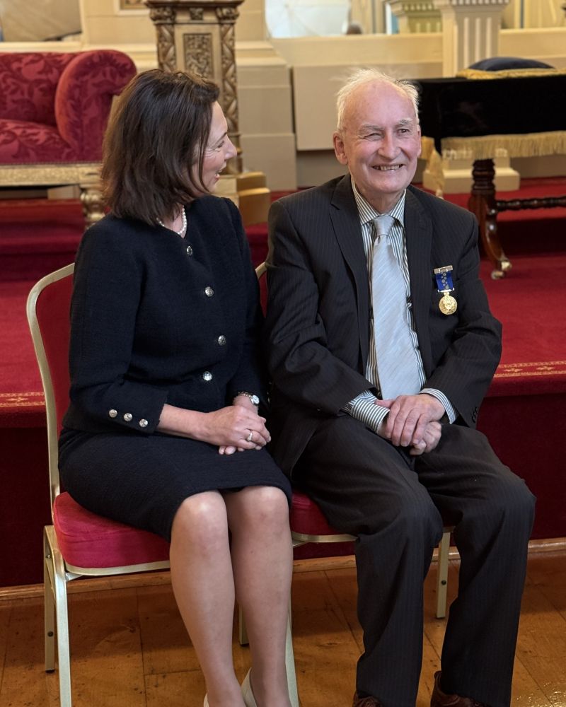 The Governor sits next to a man