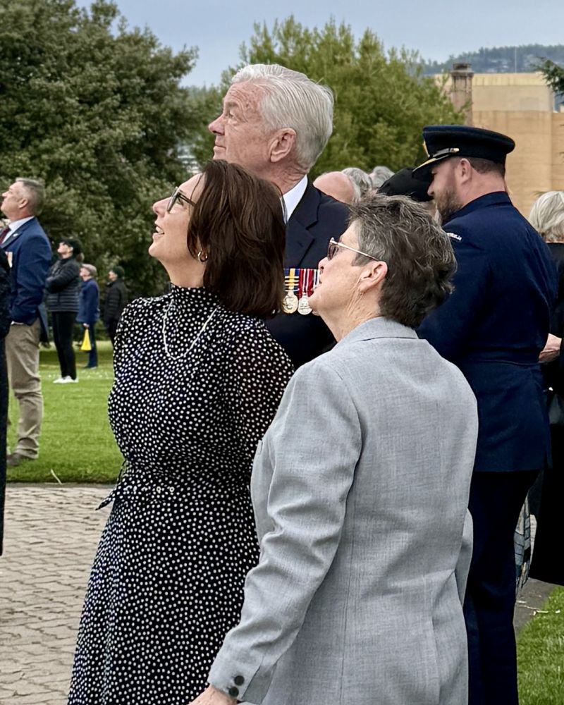 The Governor, Dr Walters and a woman stand outdoors looking up to the sky