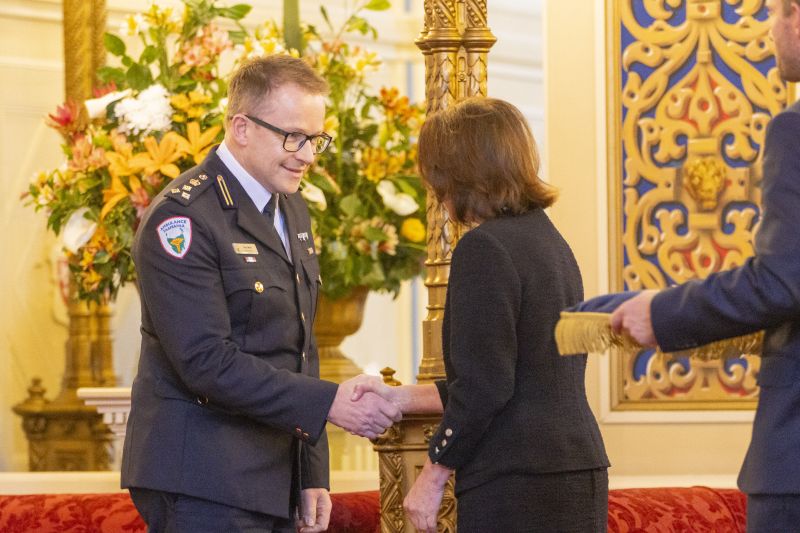 The Governor pins a medal on a man