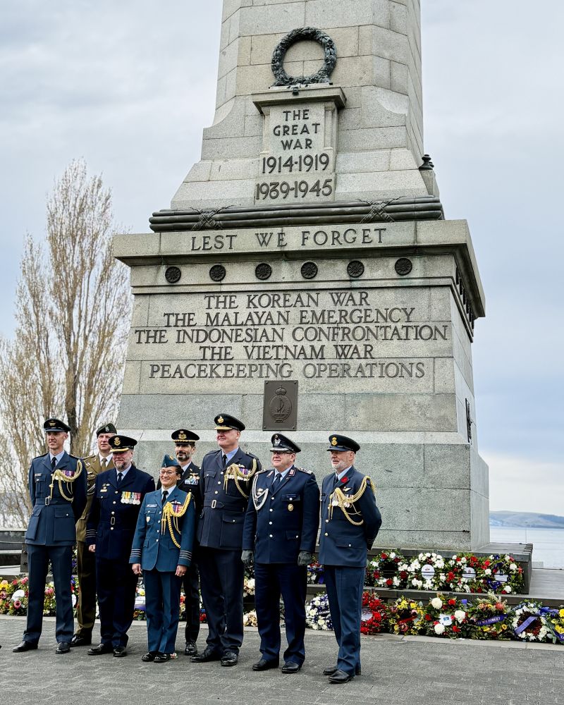 A group of people wearing military uniforms stand at the Hobart Cenotaph