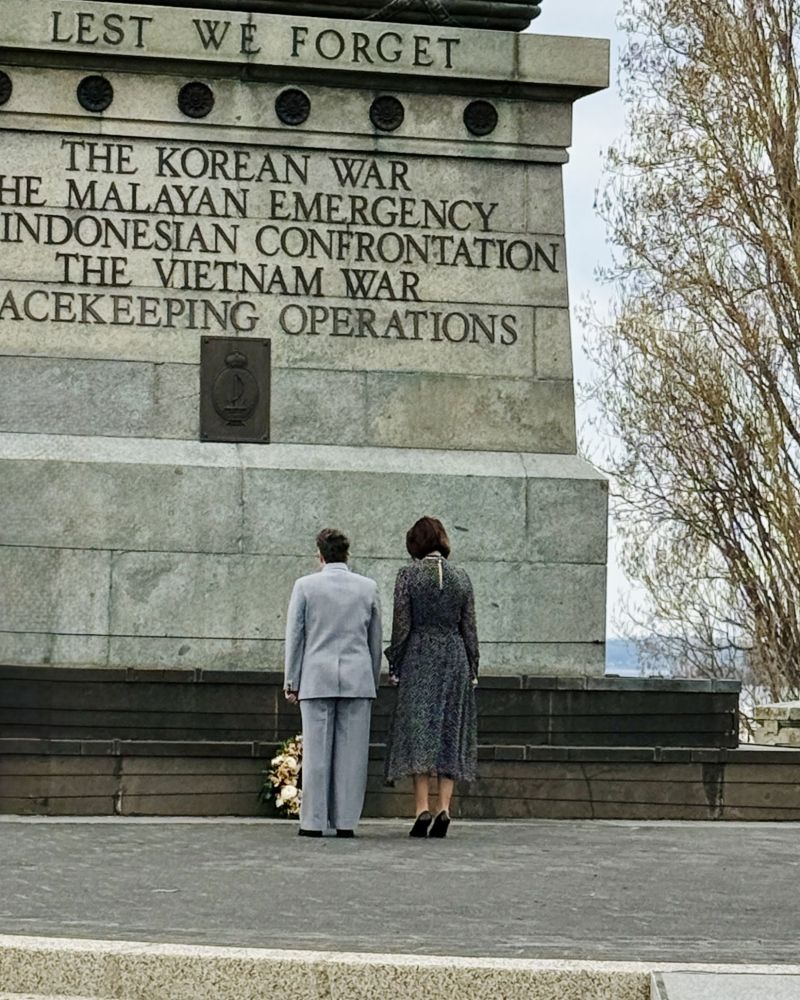 The Governor and a woman lay a floral tribute at the Hobart Cenotaph