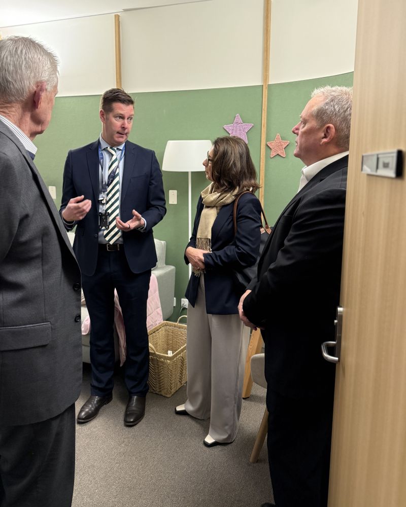 The Governor and Dr Walters stand indoors talking to two Tasmania Police officer wearing plain clothes