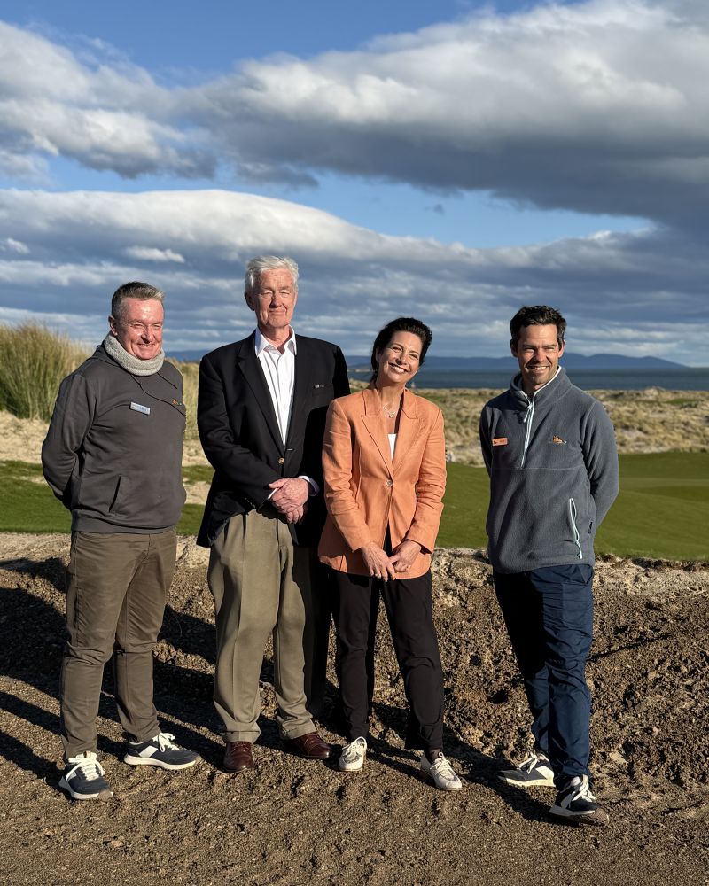 The Governor and Dr Walters stand outdoors with two men, behind them is a golf course