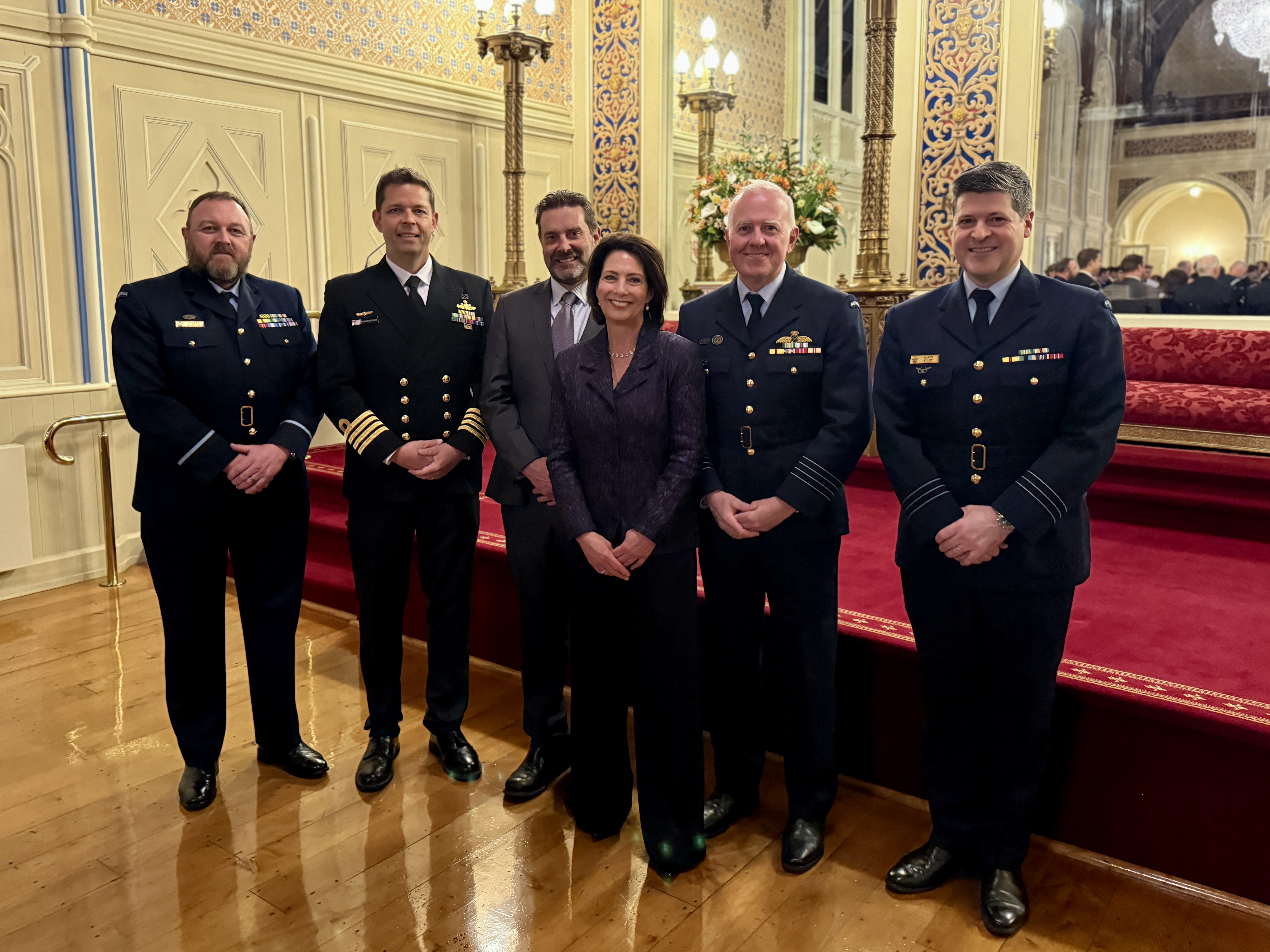 The Governor stands with five men in the Government House ballroom