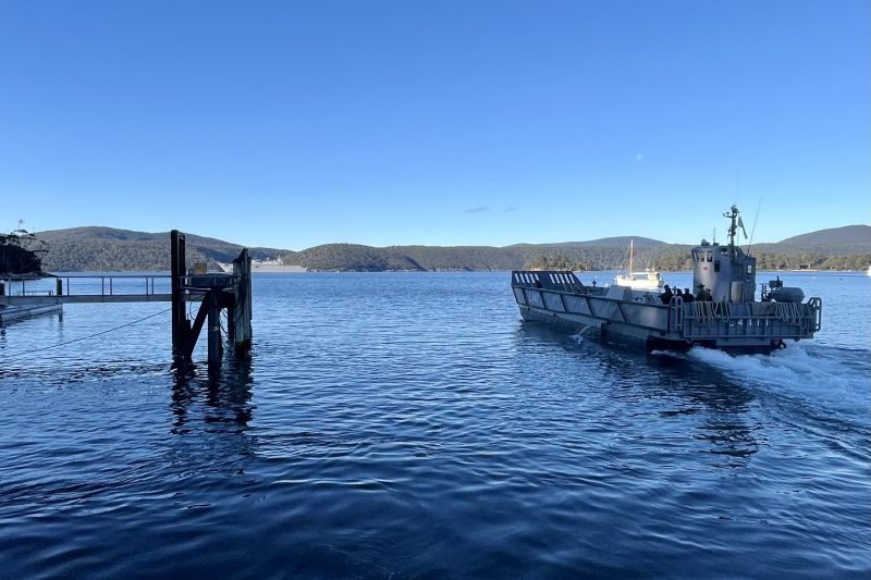 A landing craft transports the Governor to HMAS Canberra at Port Arthur