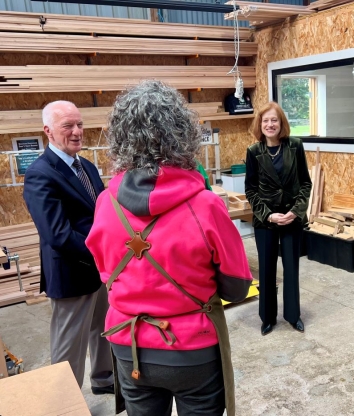 The Governor and Professor Chalmers in a woodworking workshop talking to two women