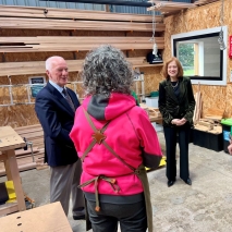 The Governor and Professor Chalmers in a woodworking workshop talking to two women
