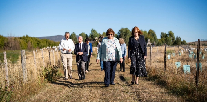 Her Excellency walking with a group of people near fields