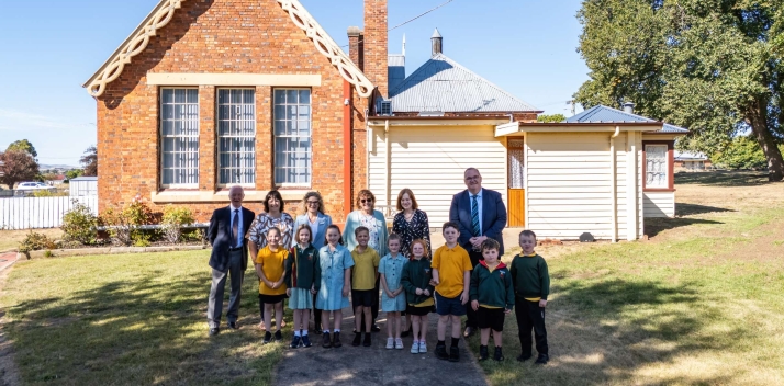 Her Excellency with a group of students and teachers outside a school