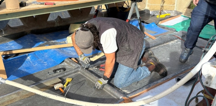 A man working with lead on the roof of the Clock Tower
