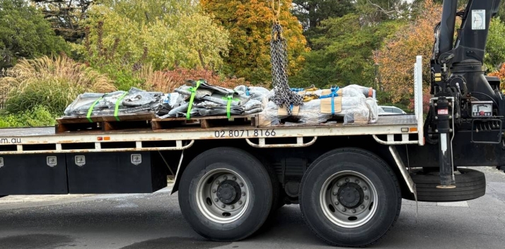 A truck with used lead on the back in the Government House driveway