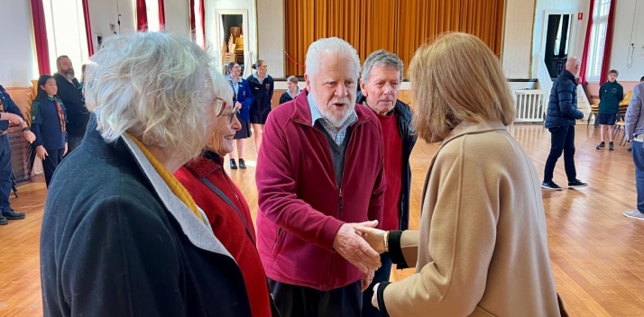 The Governor shaking hands with people inside a community hall