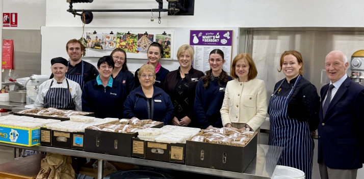 The Governor and Professor Chalmers with a large group of people in the Government House kitchen