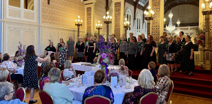 A choir performs on stage during the 2026 International Women's Day luncheon.